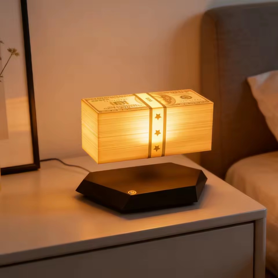 Floating Money Lamp glowing warm orange on a nightstand